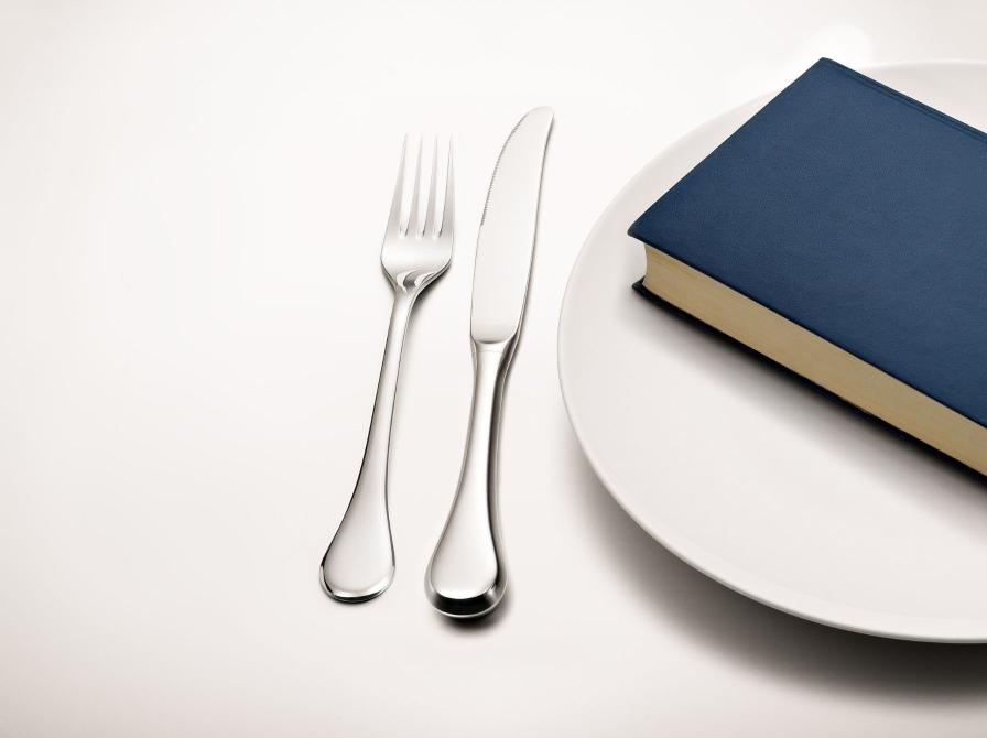 Billede af bestik, tallerken og bog